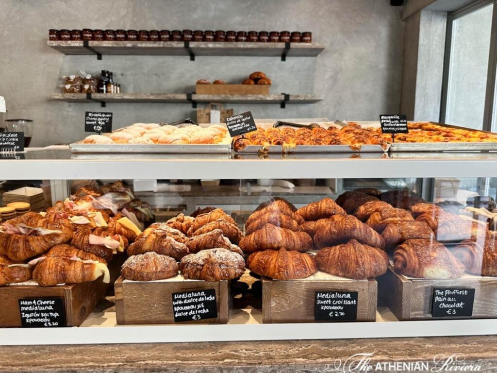 Brunch table outside a Glyfada café with coffee, pastry, and palm-lined street in background