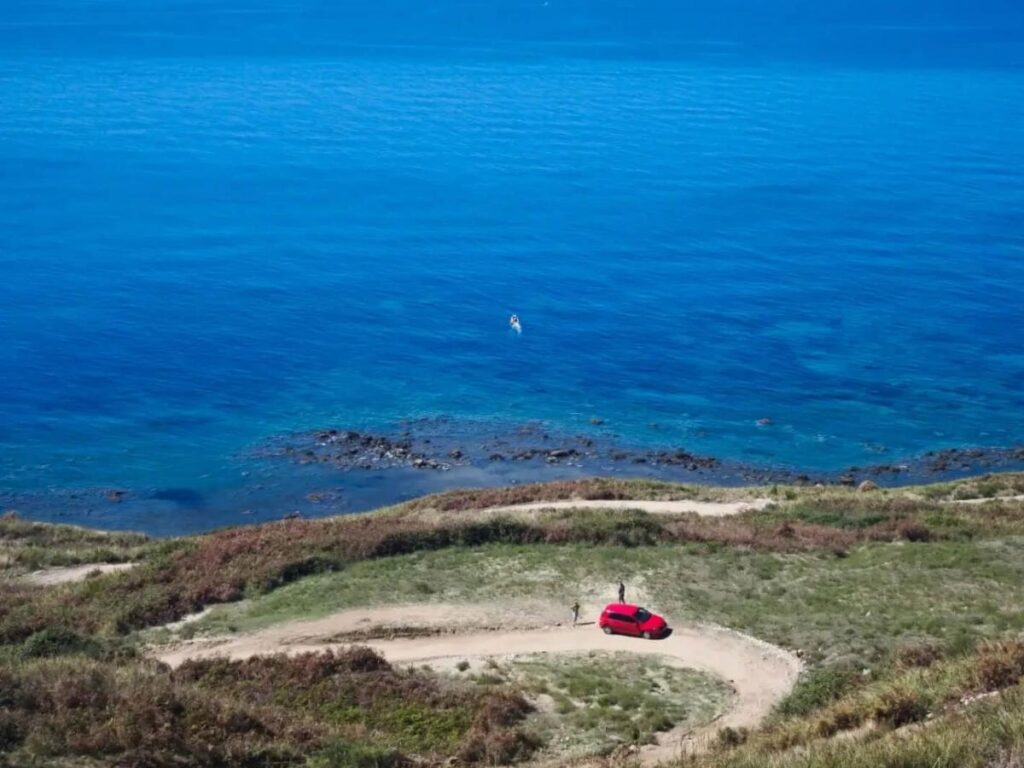 Aerial shot of Gramma Bay with bright turquoise water and steep cliffs