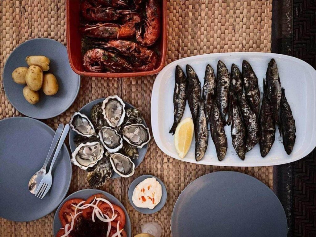 Plate of charcoal-grilled sardines with lemon at a waterfront tasca in Olhão, Portugal.”