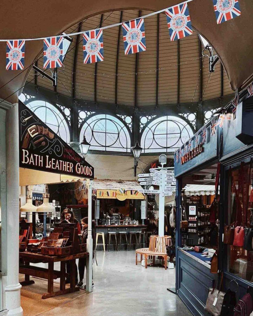 Food stalls inside Bath’s Guildhall Market offering baked goods and local snacks