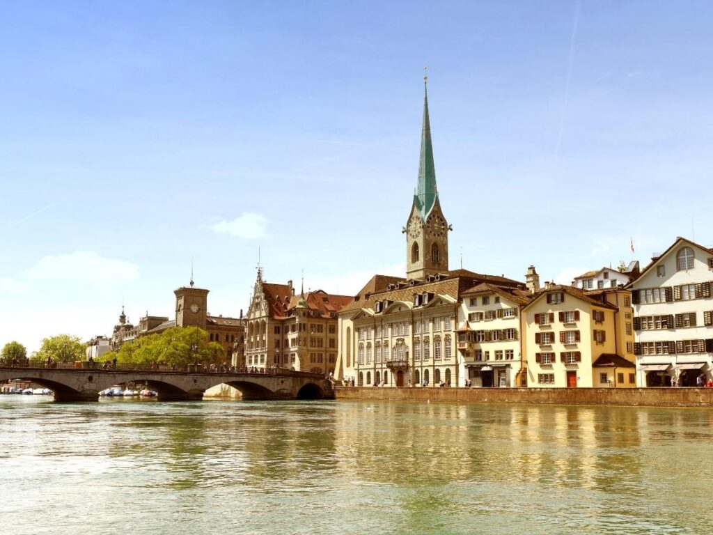 Riverside cafés along Limmatquai with reflections in the water