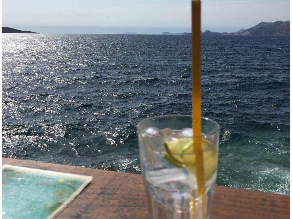 Sunset at Little Star Bar with a spritz in the foreground and boats bobbing on the harbour as the sky turns orange