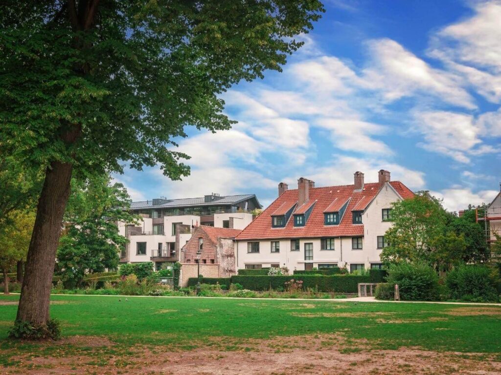 Quiet morning scene at Minnewater Park in Bruges with light mist over the lake and trees