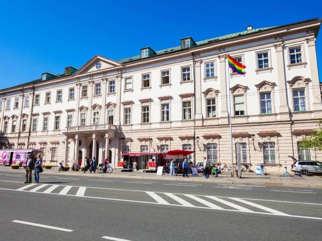 Quiet residential street near Mirabell Palace with trees, cafés, and pastel buildings