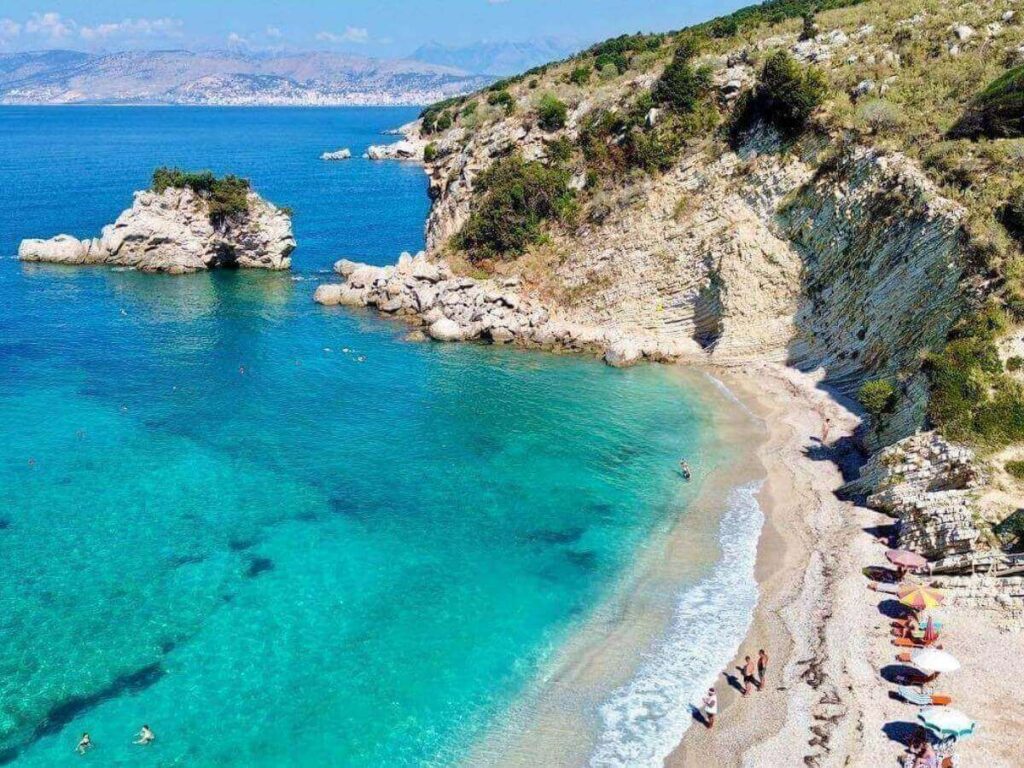 Mirror Beach cove with glassy water reflecting the sky and a small stretch of shingle shoreline