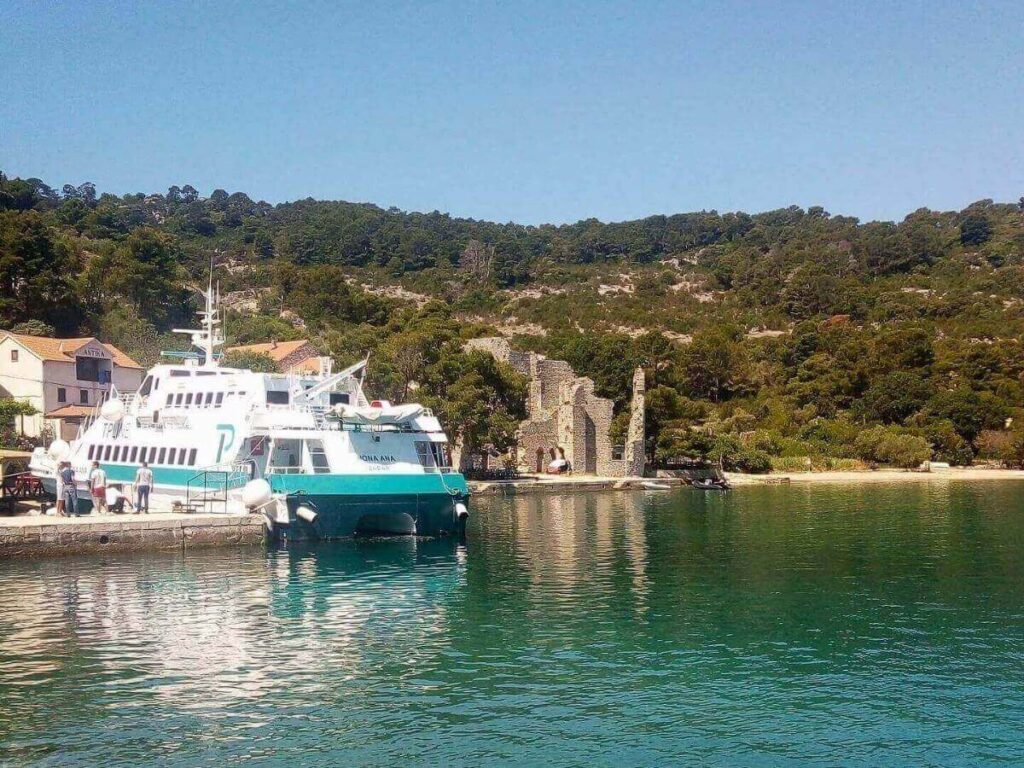 Small harbour at Polače/Pomena at dusk, boats bobbing and restaurants lit along the waterfront