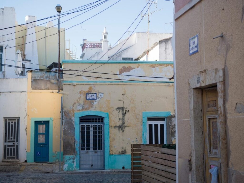 Narrow tiled alley and whitewashed houses in Olhão’s old town, Olhão, Portugal