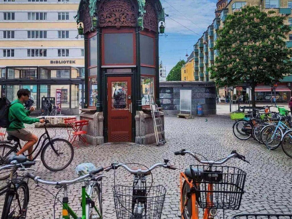 Locals cycling through a sunny Copenhagen street lined with pastel buildings