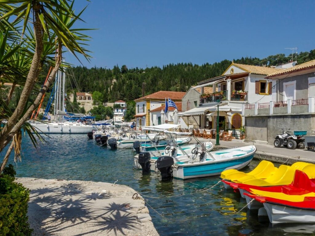 Lakka village in Paxos at dusk with pastel buildings and calm water in the bay