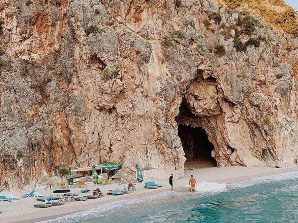 “Small boat entering Pirate’s Cave along the rocky coastline near Dhërmi