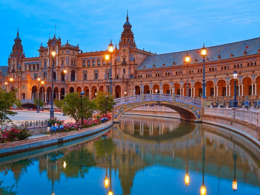 Rowboats drifting on the canal at Plaza de España with tiled colonnades