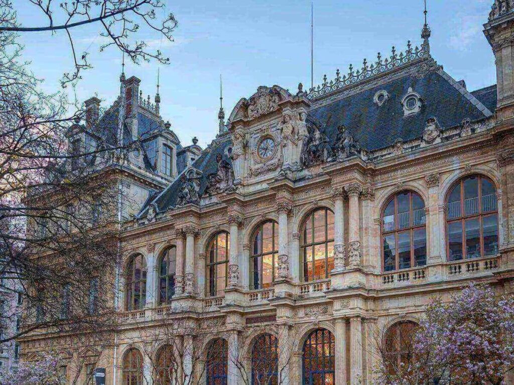 Soft morning light over Lyon’s Presqu’île with pastel buildings reflected in the Saône River