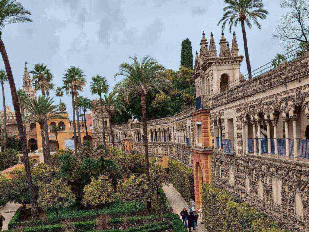 Intricate tilework and shaded arches inside the Royal Alcázar gardens
