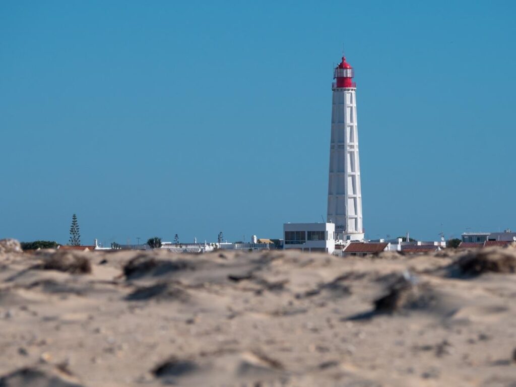 Pastel fishing houses and a sandy lane in Culatra village, Ria Formosa