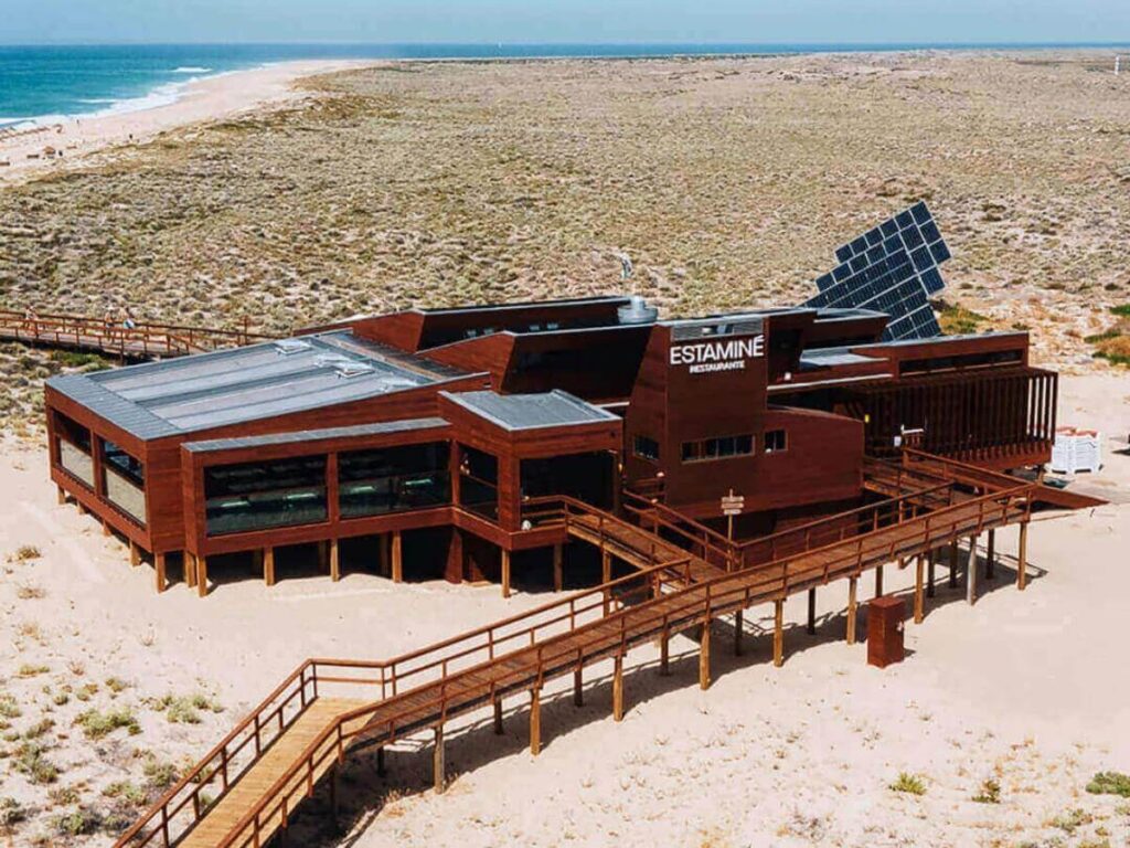 Wooden Estaminé restaurant on Ilha Deserta with tables overlooking the sea