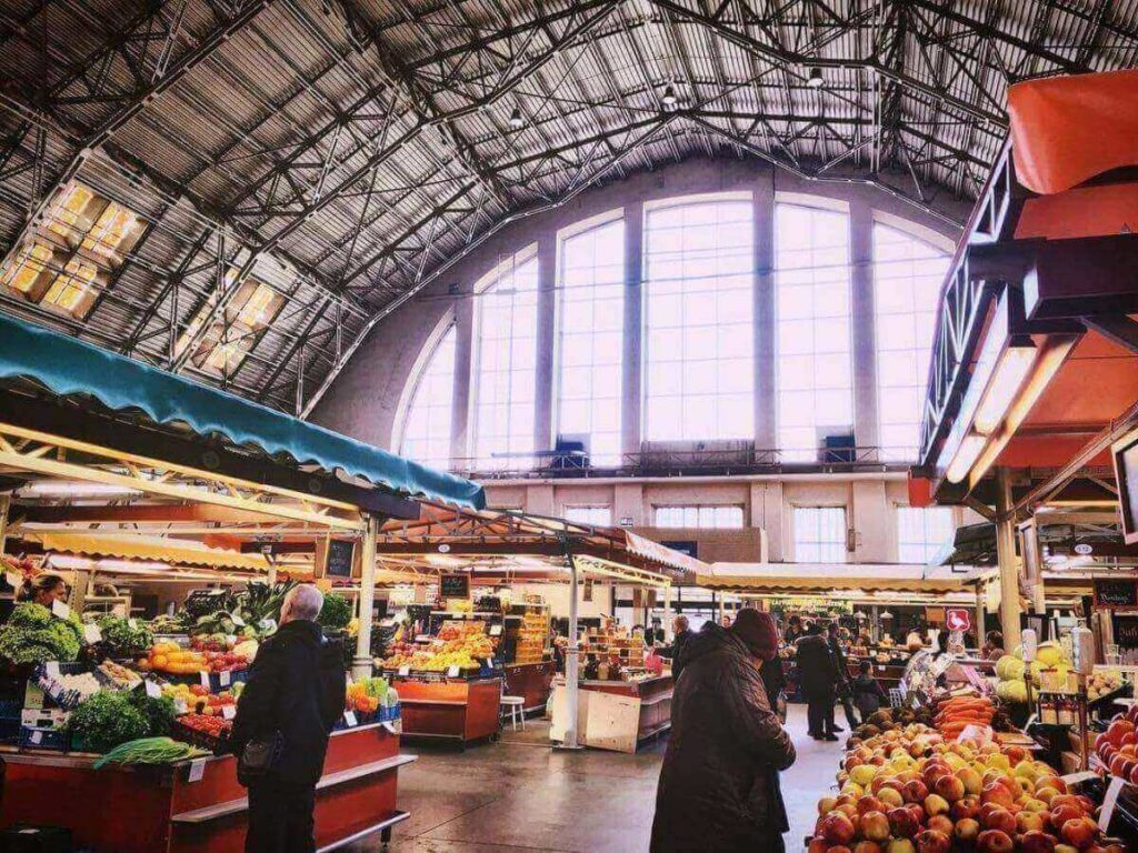 Busy aisles inside Riga Central Market with vendors and fresh produce