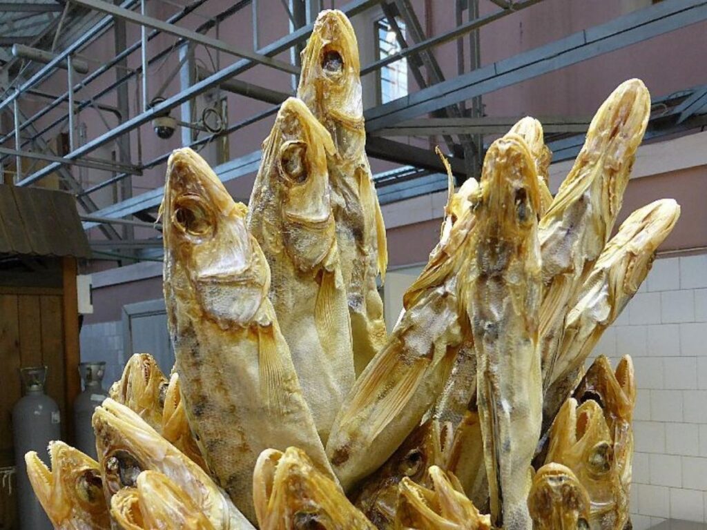 Smoked fish on a slice of dark rye bread at a market stall in Riga