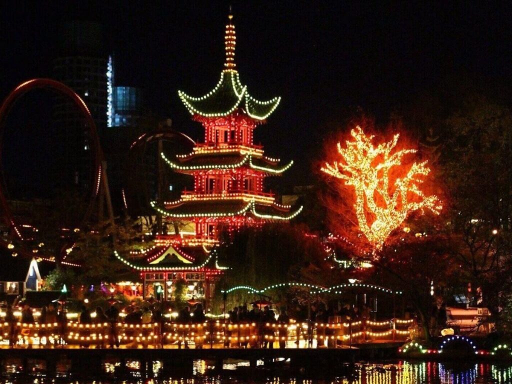 Lanterns and illuminated rides at Tivoli Gardens amusement park in Copenhagen at night