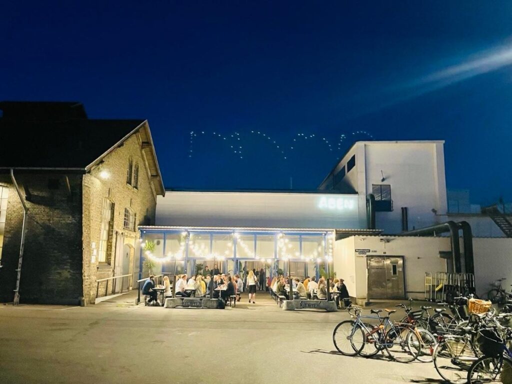 People dining outdoors at the Kødbyen Meatpacking District in Vesterbro, Copenhagen