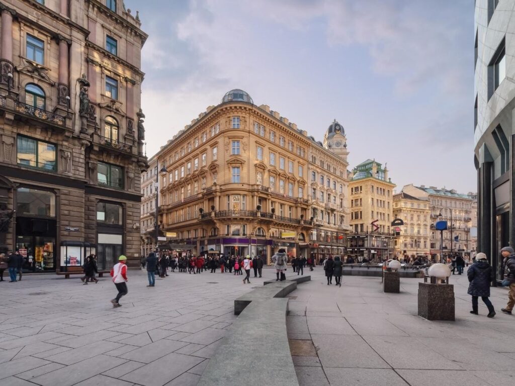 A street violinist playing near a historic fountain in Vienna’s old town