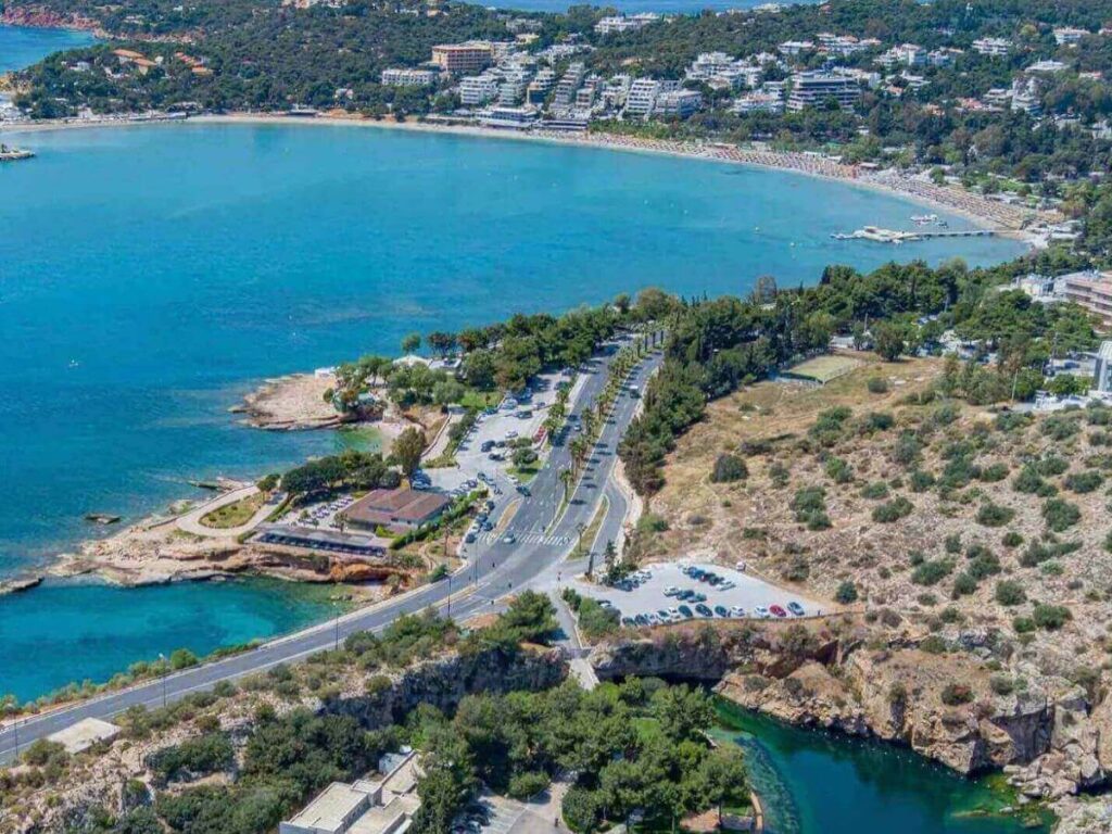 Small rocky cove near Vouliagmeni with crystal clear water and swimmers
