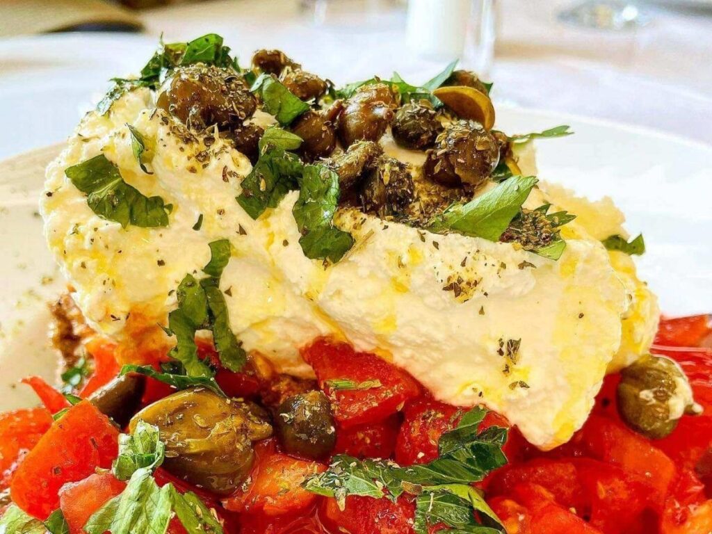 Lunch table at a seaside taverna in Vouliagmeni with grilled fish, lemon, and a view of the water