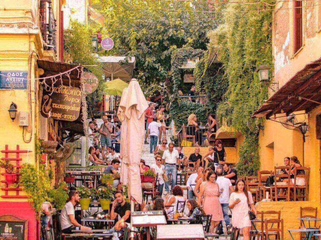 Outdoor stone steps at Yiasemi Café in Plaka, lined with colorful cushions and small tables under the sun.