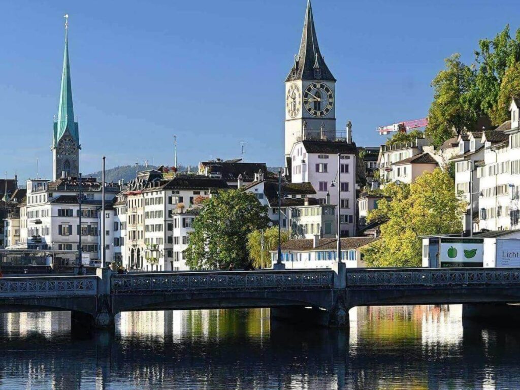 Old Town buildings along the Limmat River with church towers and reflections on the water