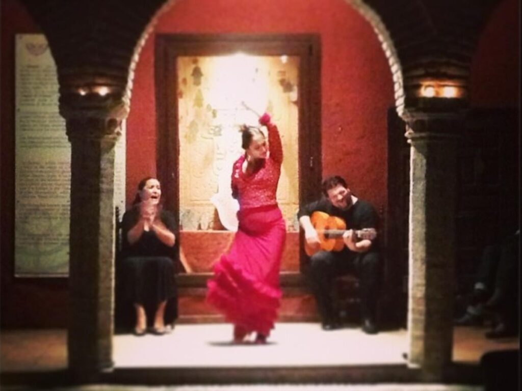 Small flamenco performance in an intimate courtyard with a singer and guitarist