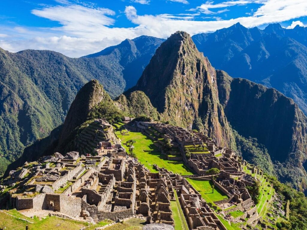 Travel bucket list destinations featuring Santorini Greece and Machu Picchu Peru