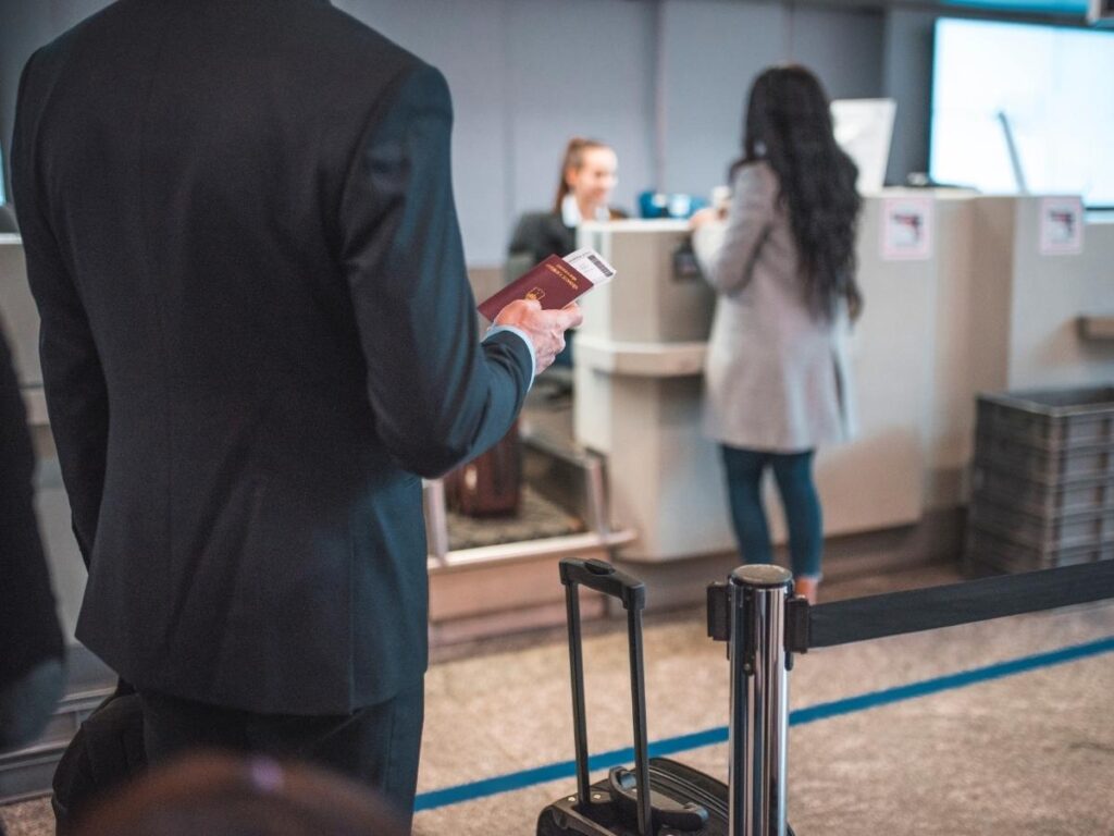 Traveler checking in suitcase at airline counter
