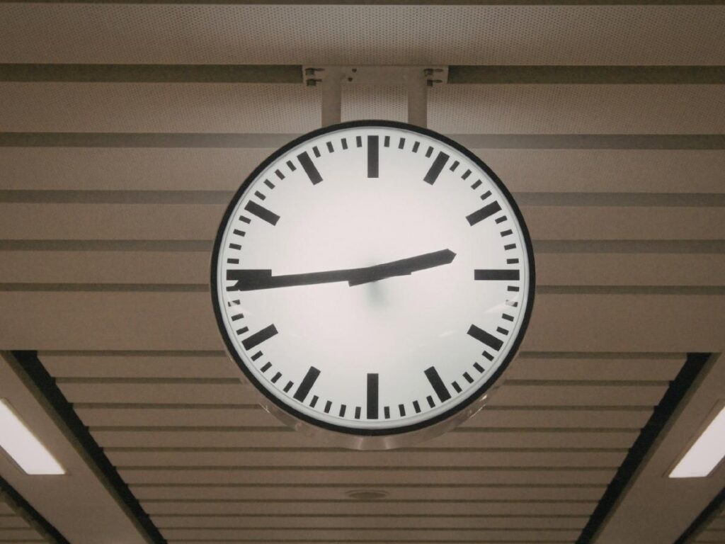 Large airport terminal clock showing time before flight departure