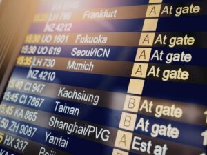 Traveler rushing through airport terminal with luggage checking watch before flight departure