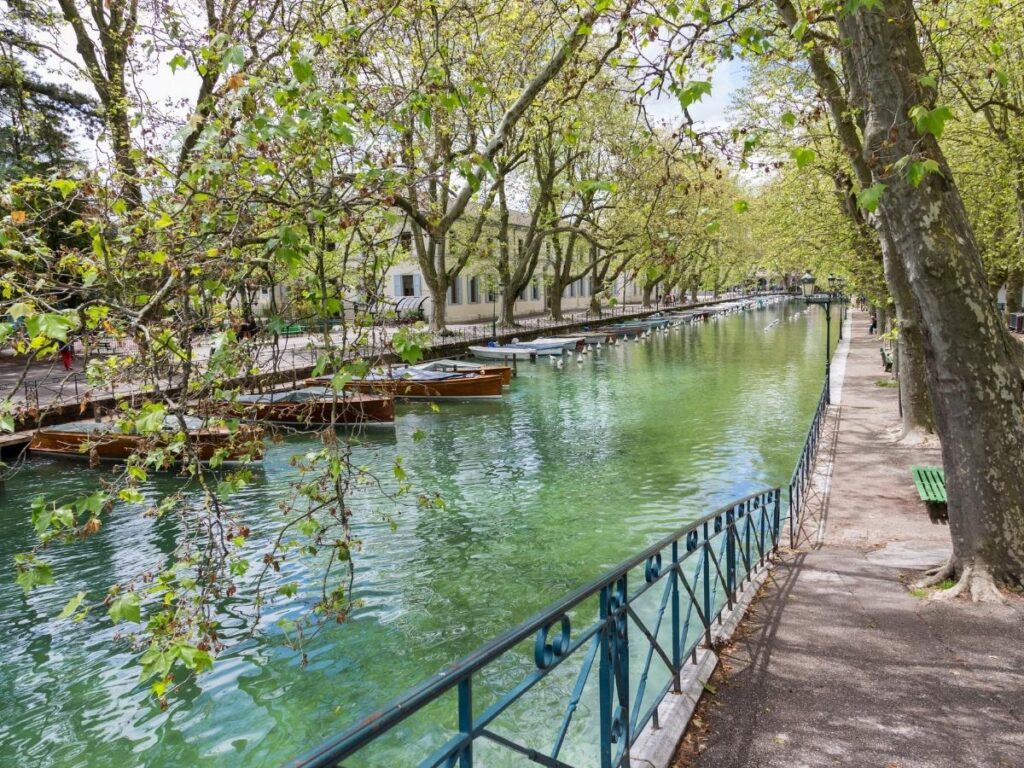 Old town canals and pastel buildings with Lake Annecy and mountains in Annecy, France