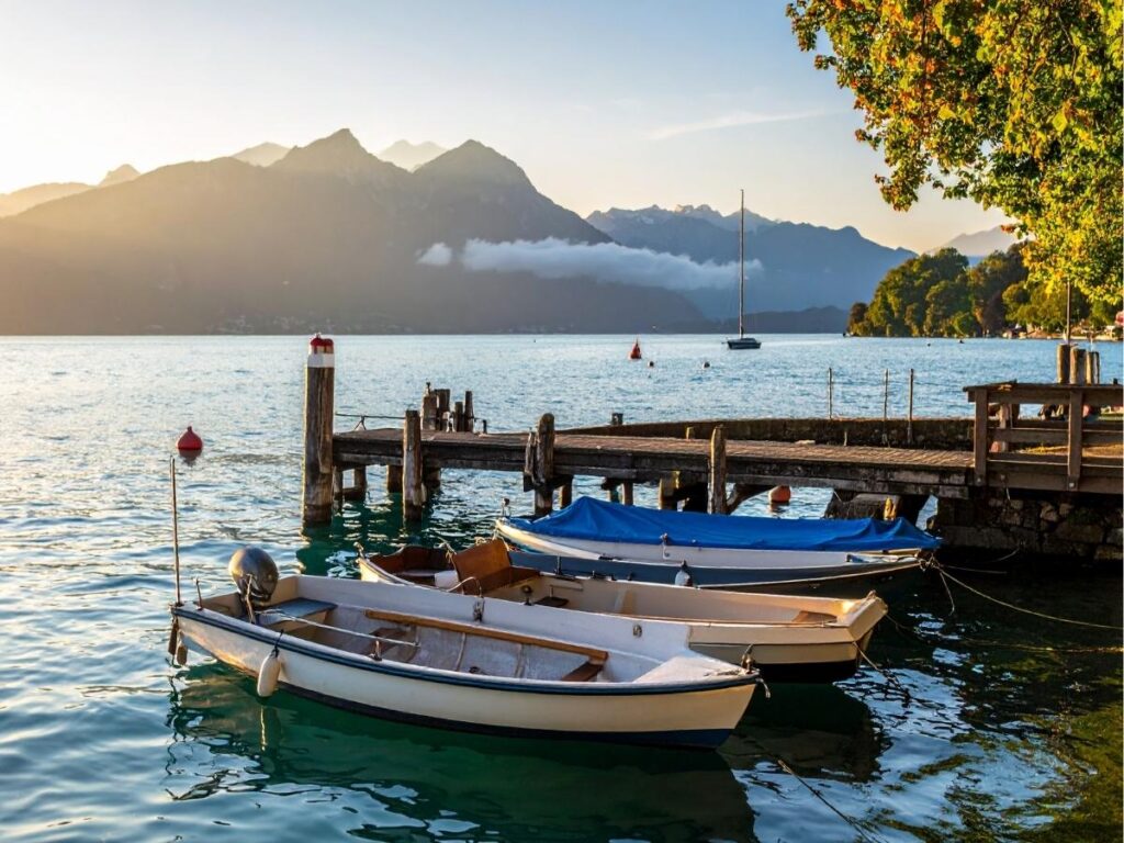 Crystal clear Lake Annecy with French Alps mountains reflecting in water perfect for digital nomad lifestyle