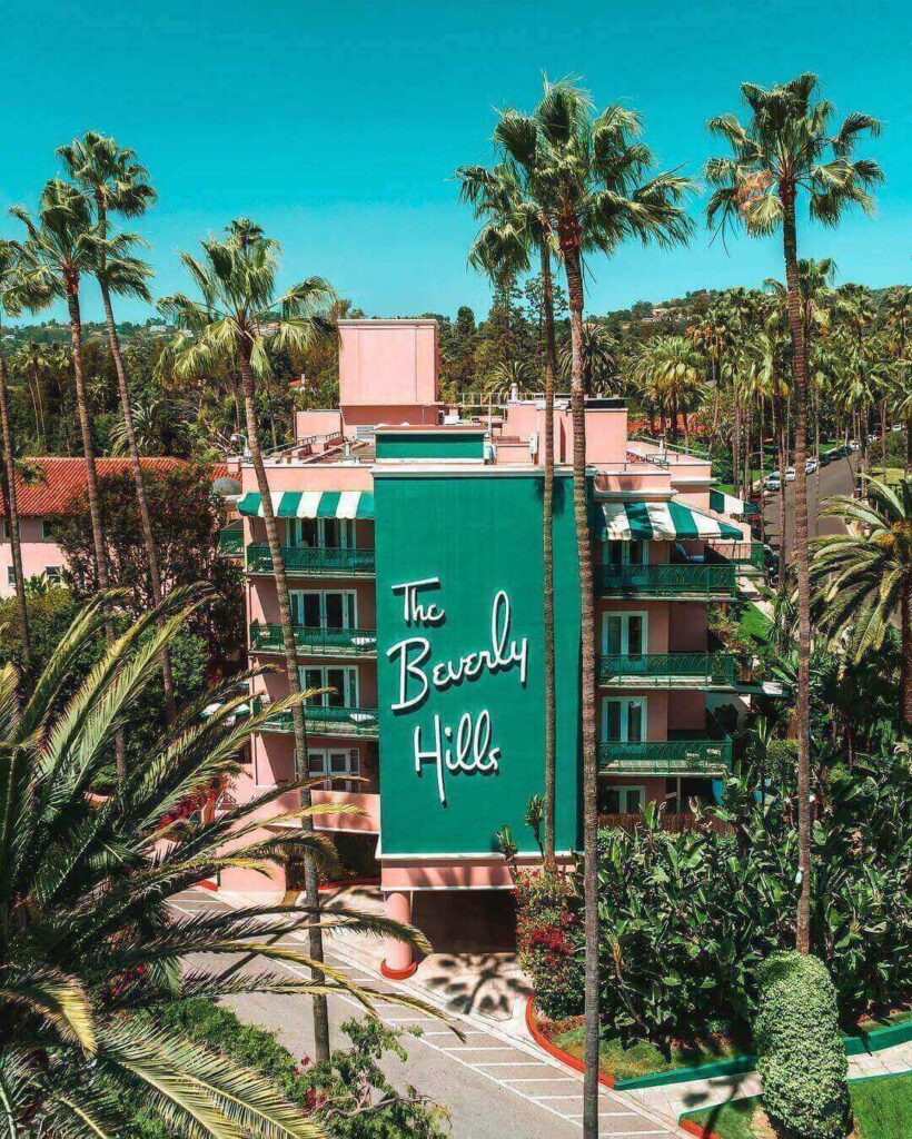 Iconic pink exterior of the Beverly Hills Hotel surrounded by palm trees
