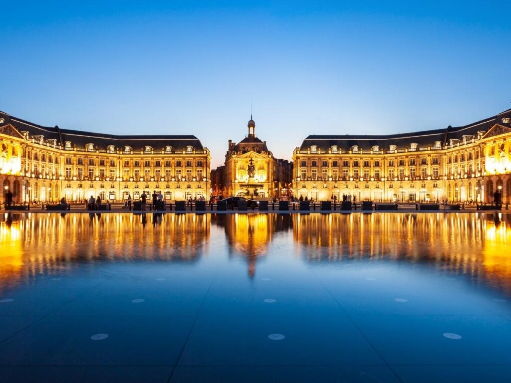 Place de la Bourse reflecting in water mirror fountain at sunset in Bordeaux wine region France