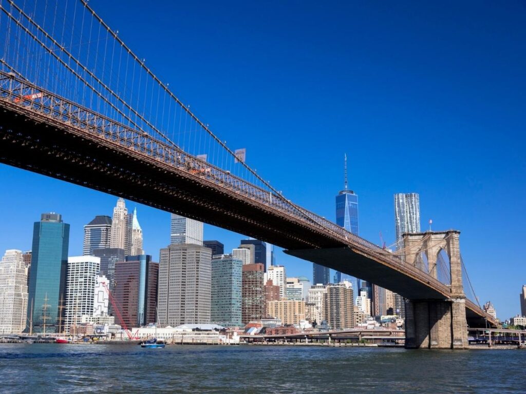 Walking across Brooklyn Bridge with Manhattan skyline in background