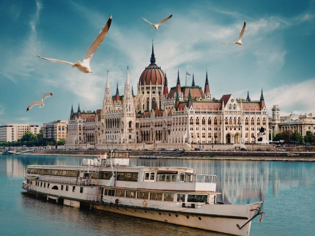 Hungarian Parliament building illuminated at sunset along Danube River Budapest