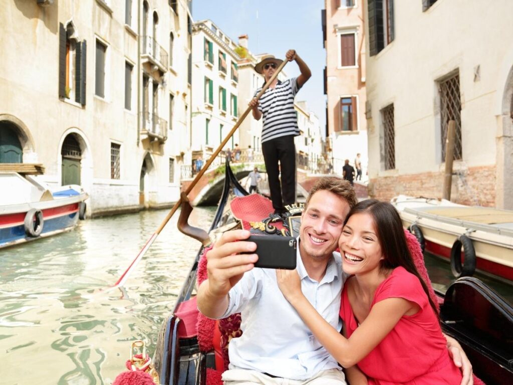 Two friends laughing naturally on Venice canal bridge during candid photography moment