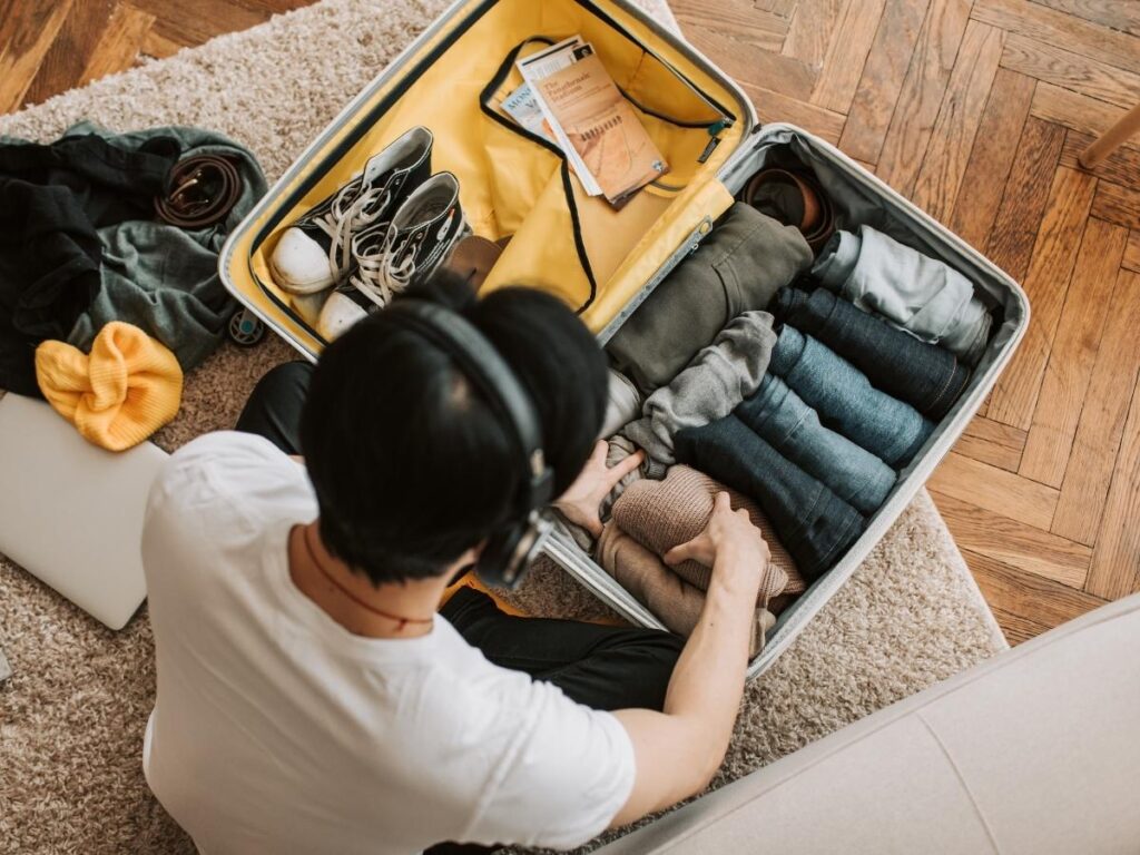 Vacuuming interior of fabric suitcase to remove dust and debris