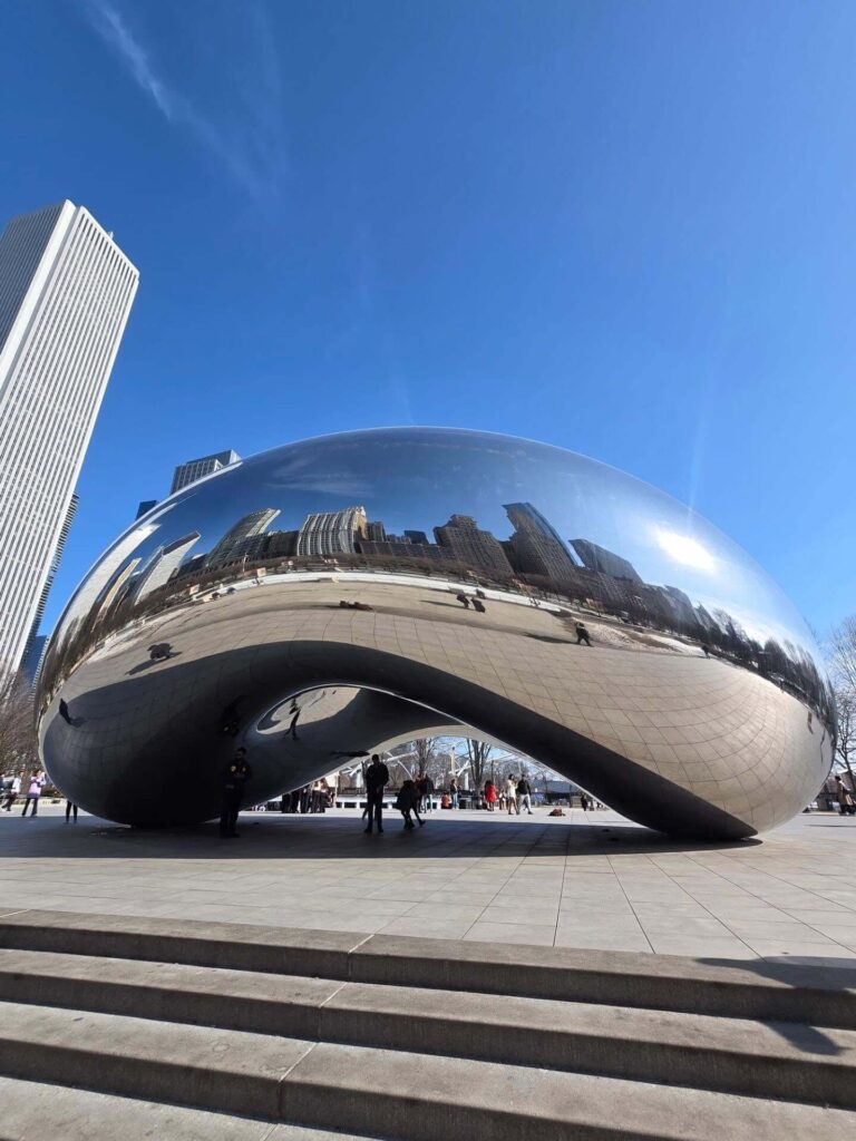 Cloud Gate sculpture reflecting Chicago skyline in Millennium Park