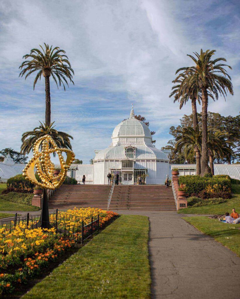 white Victorian Conservatory of Flowers surrounded by gardens in Golden Gate Park