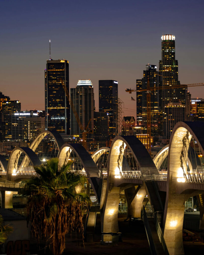 Downtown Los Angeles skyline glowing at night from a bridge viewpoint