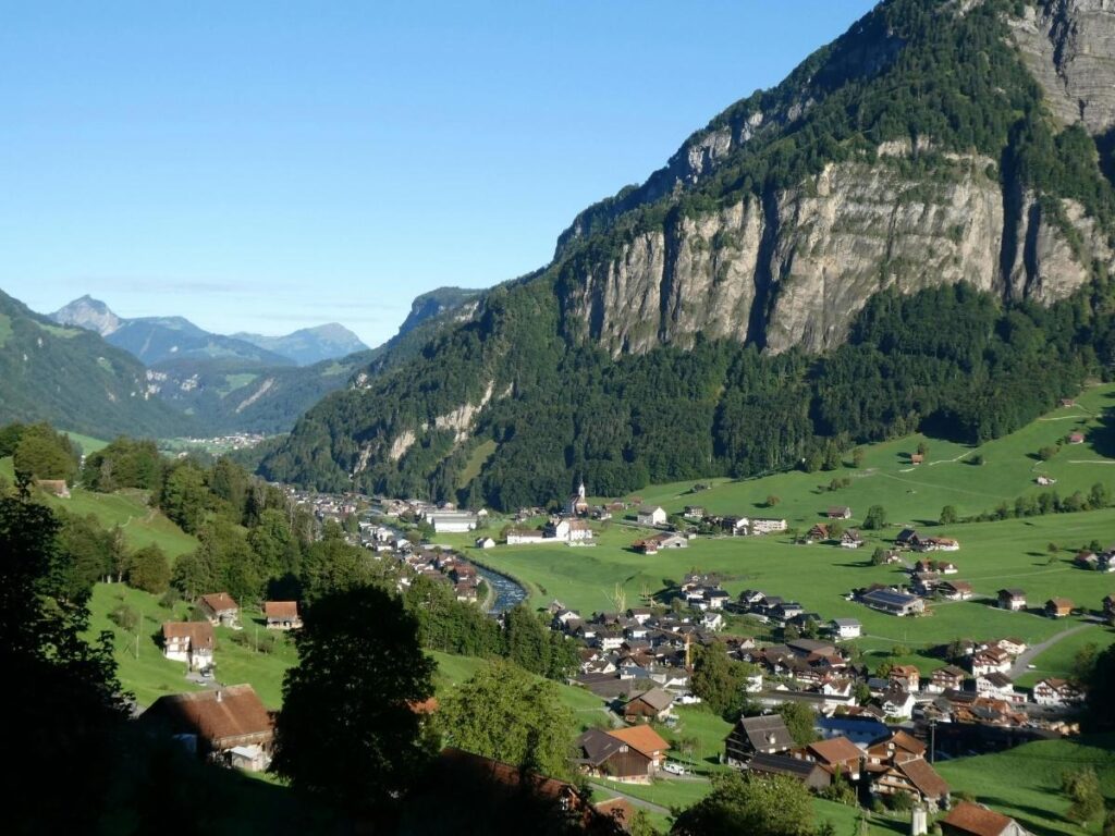 Traditional wooden chalets in car-free Gimmelwald village with snow-capped Alpine peaks