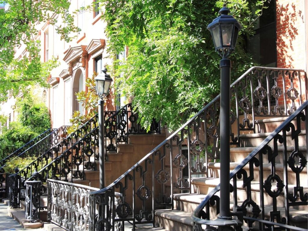 Historic brownstone buildings on tree-lined street in Greenwich Village