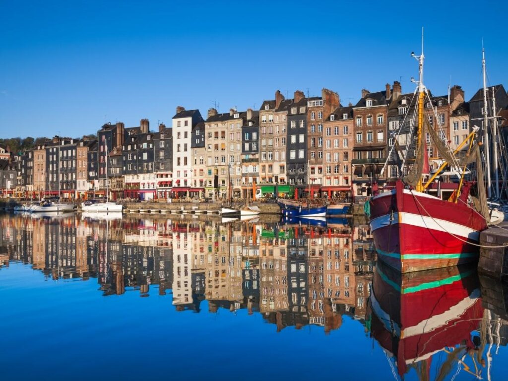 Colorful tall houses reflecting in Vieux Bassin old harbor of Honfleur Normandy
