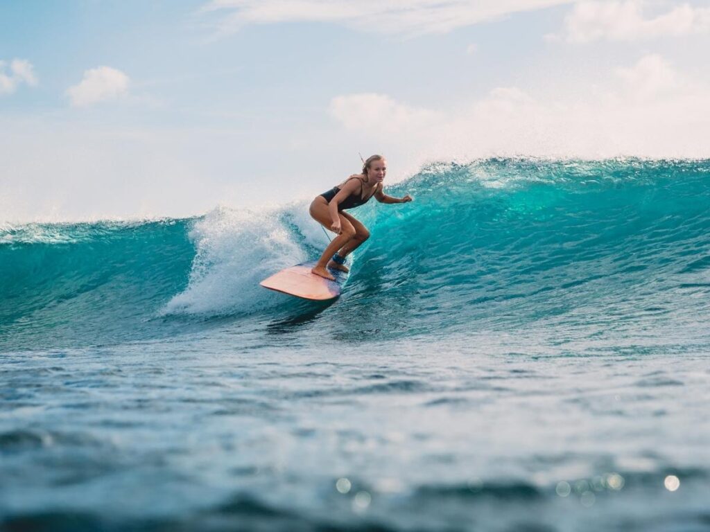 Surfers riding morning waves at Honoliʻi Beach Park near Hilo