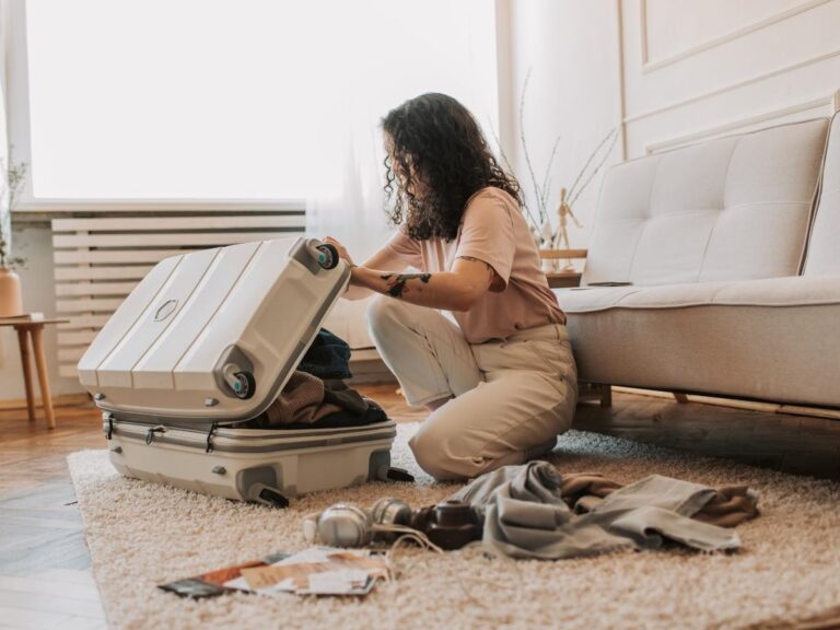 Woman cleaning hard shell suitcase with microfiber cloth after travel Placement: Top of article, before intro