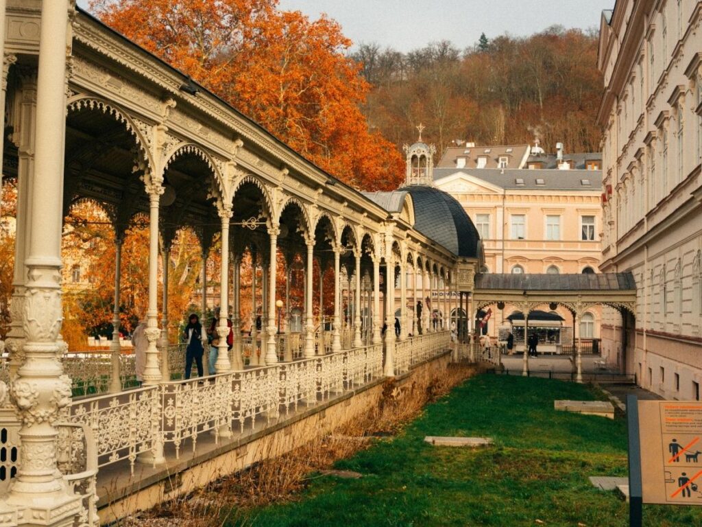 Historic spa colonnade with ornate architecture along river in Karlovy Vary, Czech Republic